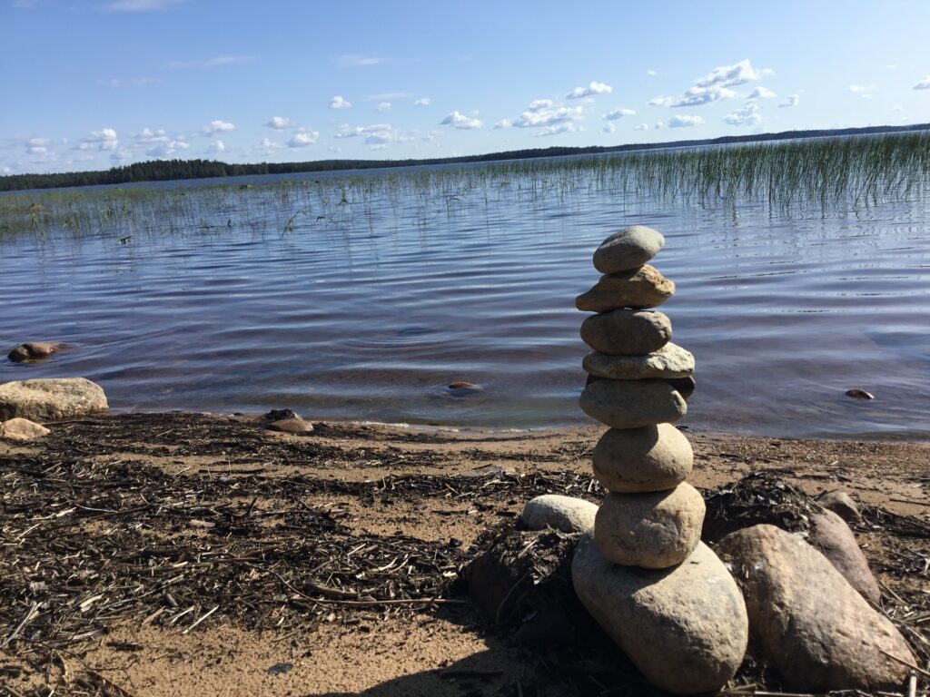 Kiviä pinottuna torniksi hiekkarannalla