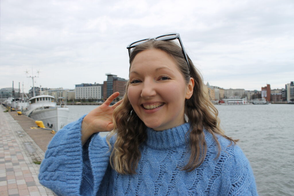 Kaisla Saarikoske hymyilee meren rannalla Helsingissä.