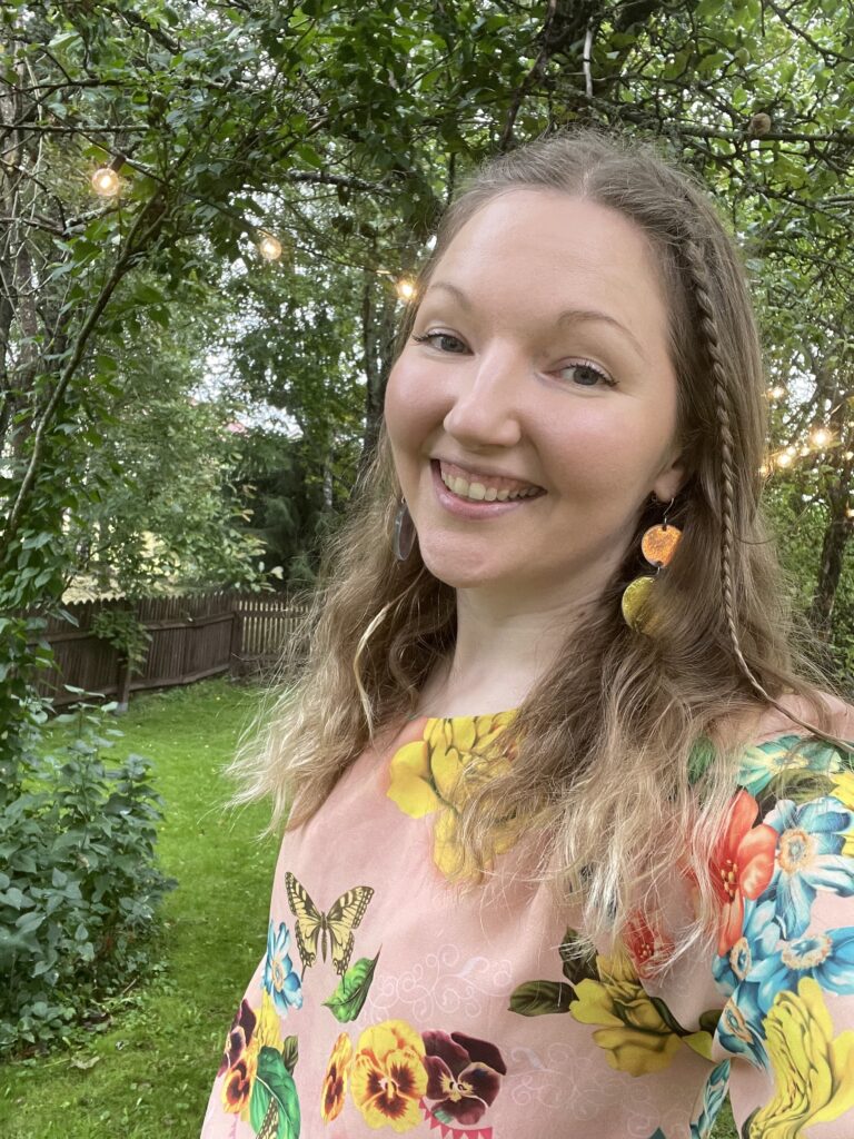 Kaisla Saarikoski hymyilee kesällä puutarhassa.