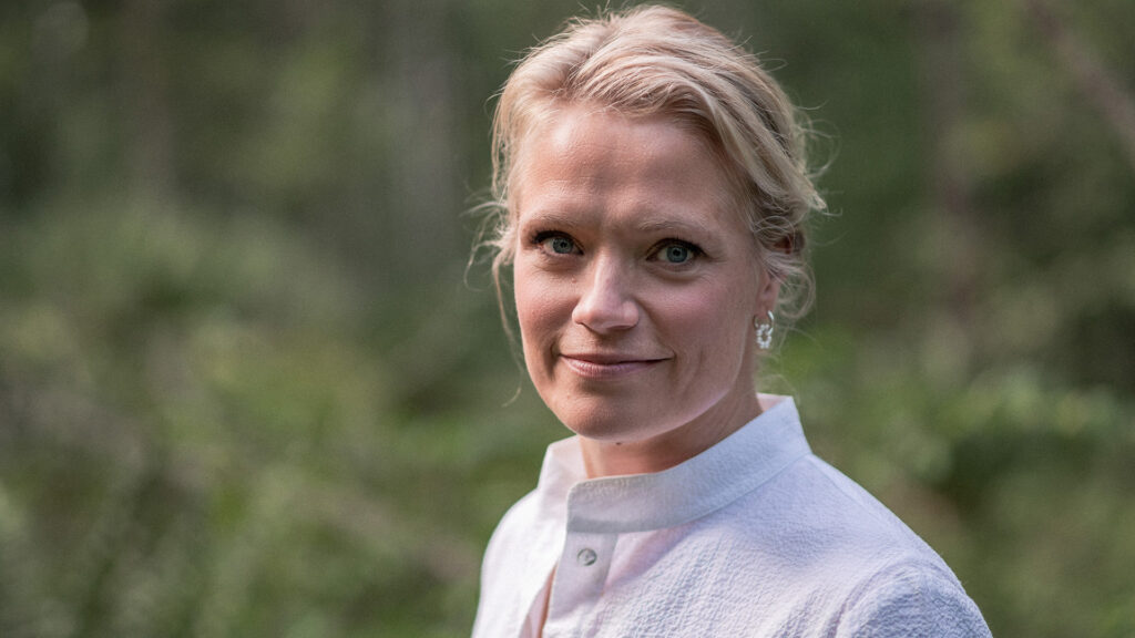 Maaret Kalliolla on valkoinen paita ja vaaleat hiukset. Hän hymyilee.